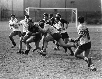 A group of men are playing a game of rugby on a field.