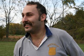 A man with a mustache is wearing a shirt that says manchester on it
