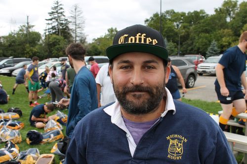 A man wearing a hat with the word coffee on it