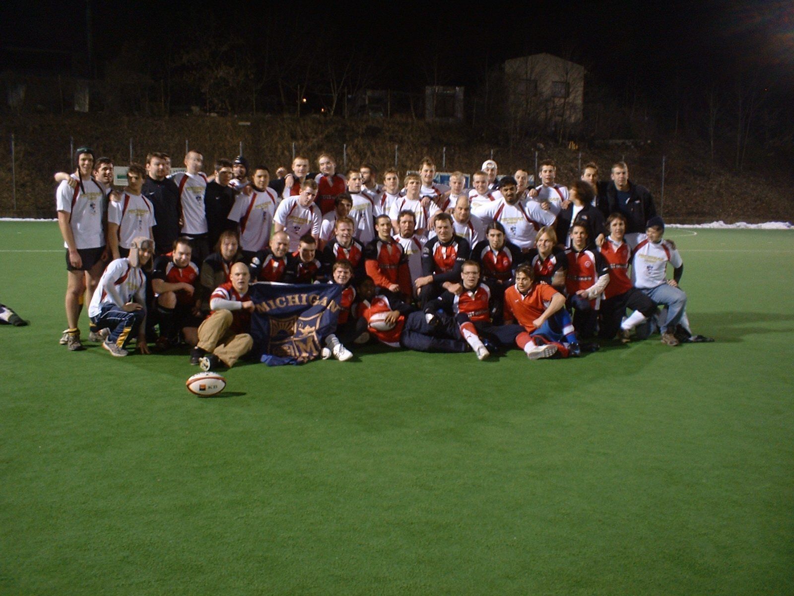 A group of people are posing for a picture on a field.