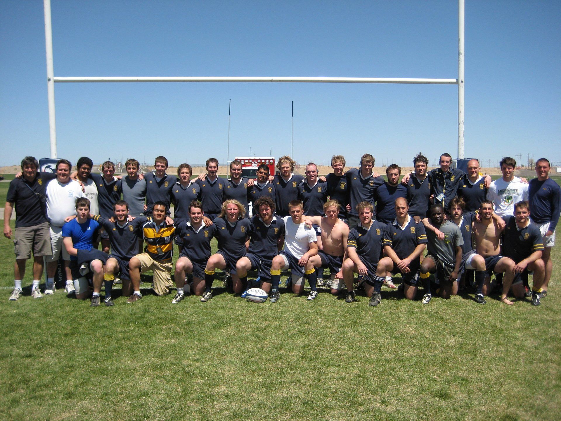A group of men are posing for a picture on a field