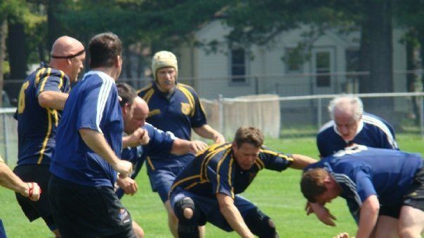 A group of men are playing a game of rugby on a field.