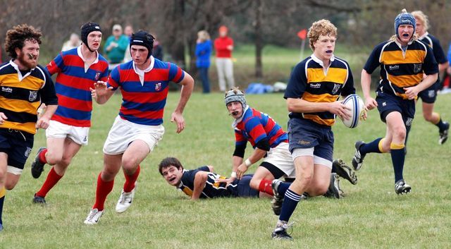 A group of young men are playing rugby on a field
