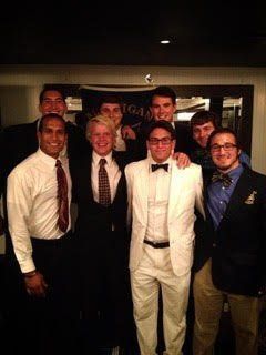 A group of young men in suits and bow ties are posing for a picture.