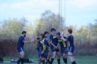 A group of young men are playing rugby on a field.