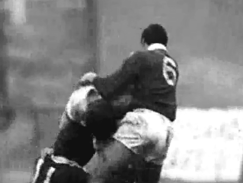 A black and white photo of two men playing rugby.