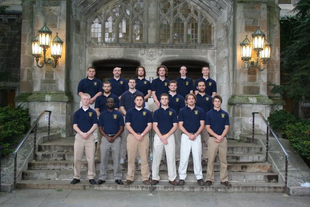 A group of men are posing for a picture in front of a building