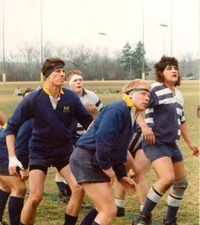 A group of people are playing rugby on a field.