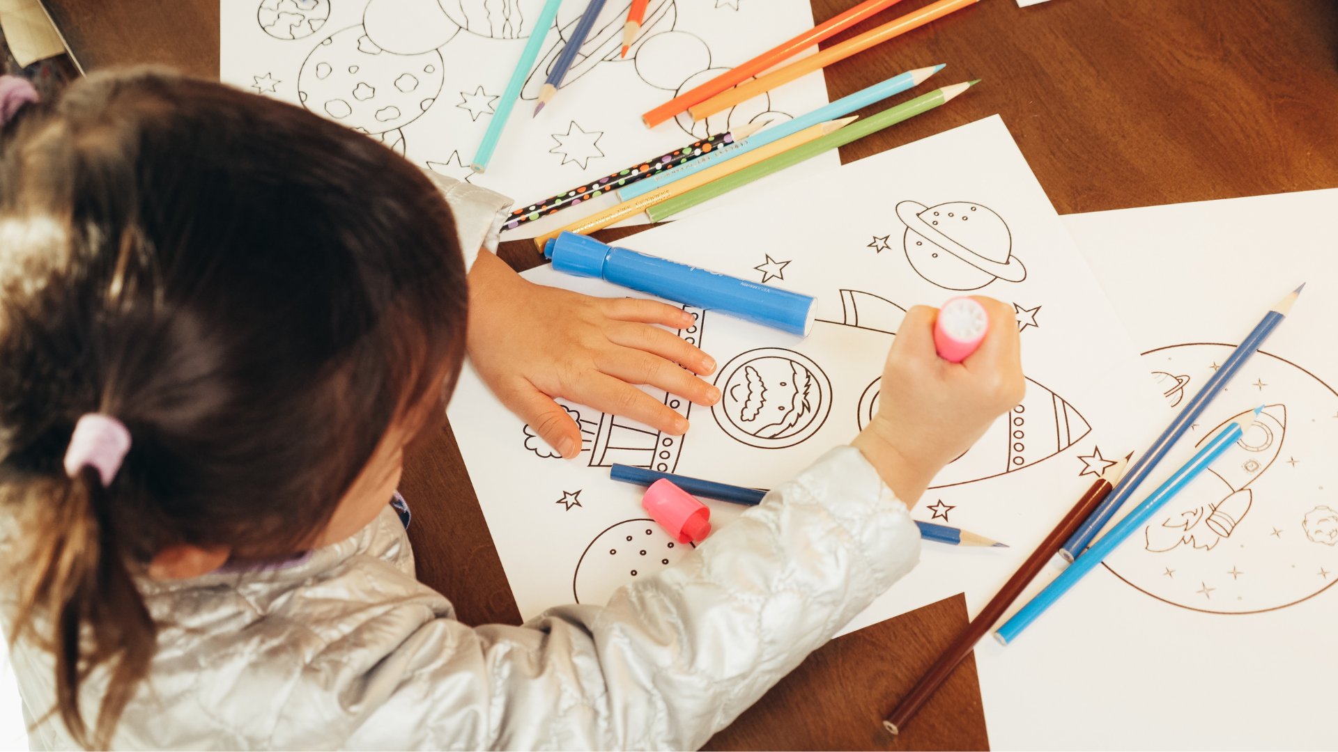 Teacher with children looking at tablet in a classroom, smiling, diverse group.