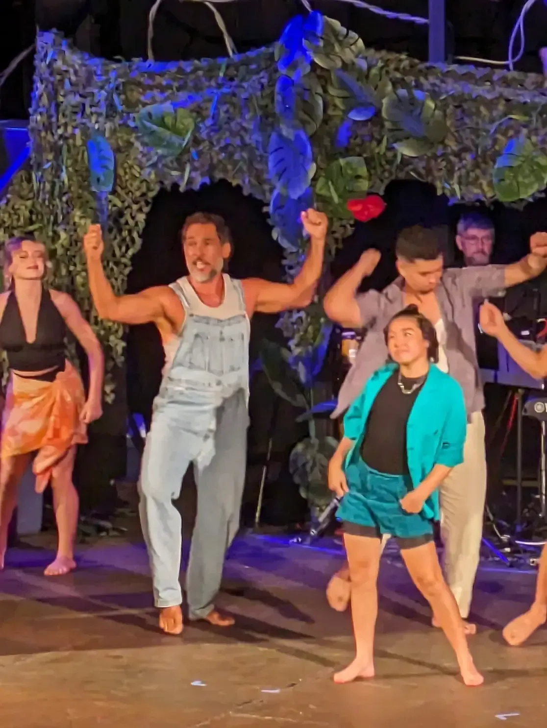 A group of people are dancing on a stage