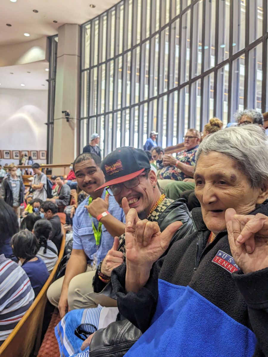 A group of people are sitting in a stadium making funny faces.