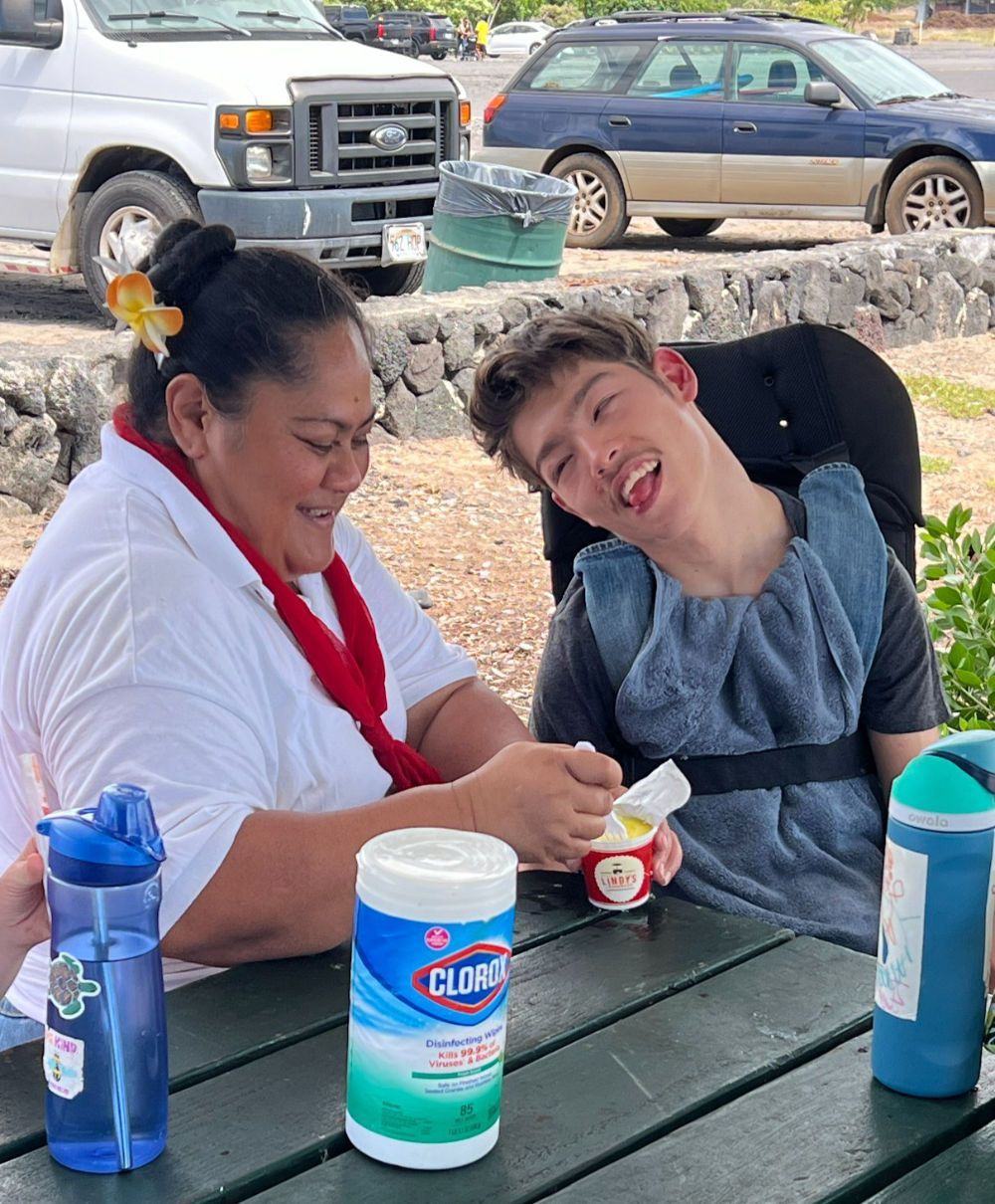 A man and a woman are sitting at a table with clorox wipes.