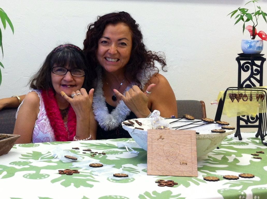 Two women are posing for a picture while sitting at a table