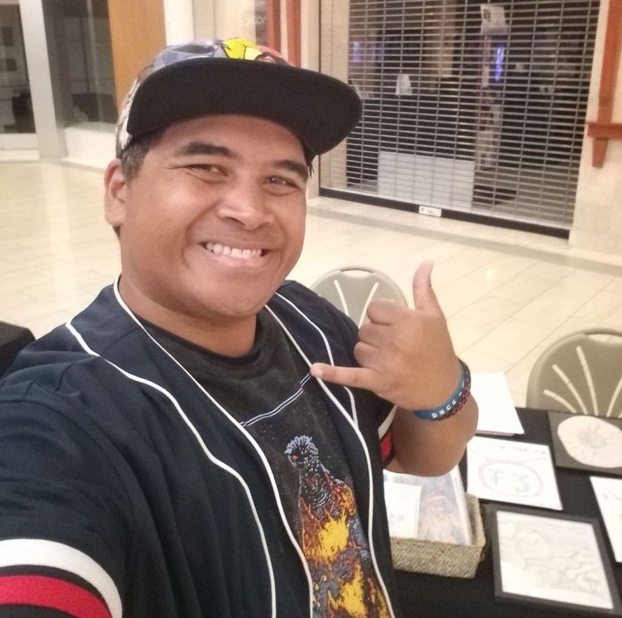 A man wearing a hat is giving a thumbs up