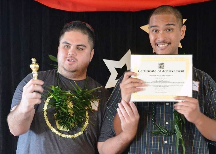 Two men holding a certificate of achievement and a trophy