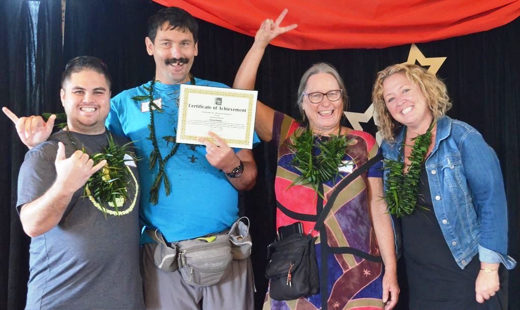 A group of people are posing for a picture and one of them is holding a certificate.