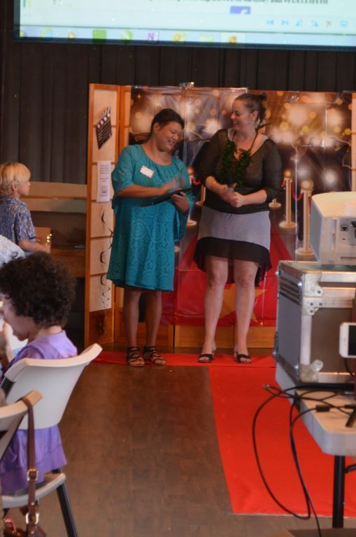 A woman in a blue dress is standing next to another woman