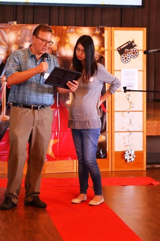 A man and a woman are standing on a red carpet