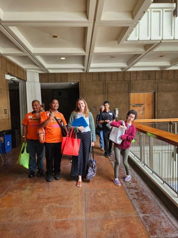 A group of people are walking down a hallway.