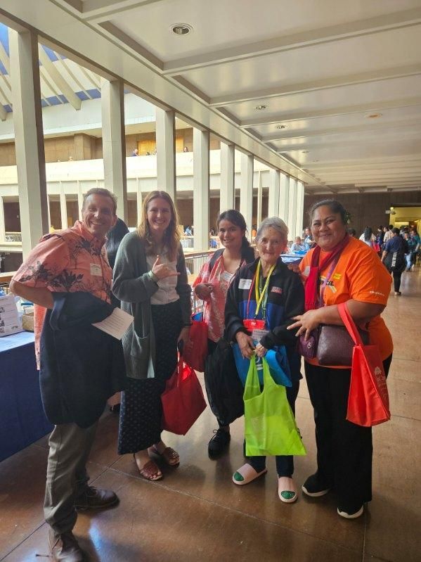 A group of people are posing for a picture in a hallway.