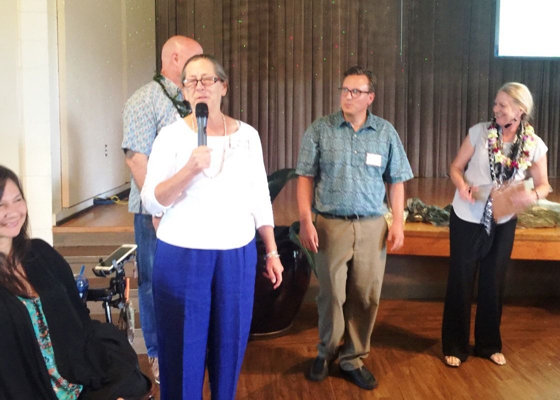 A woman is holding a microphone in front of a group of people