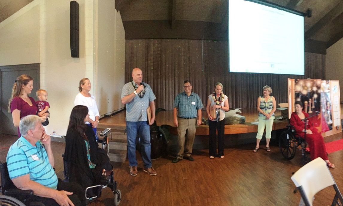 A group of people are standing in a room in front of a large screen.