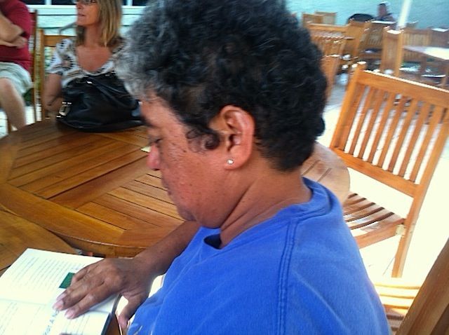 A woman in a blue shirt is sitting at a table