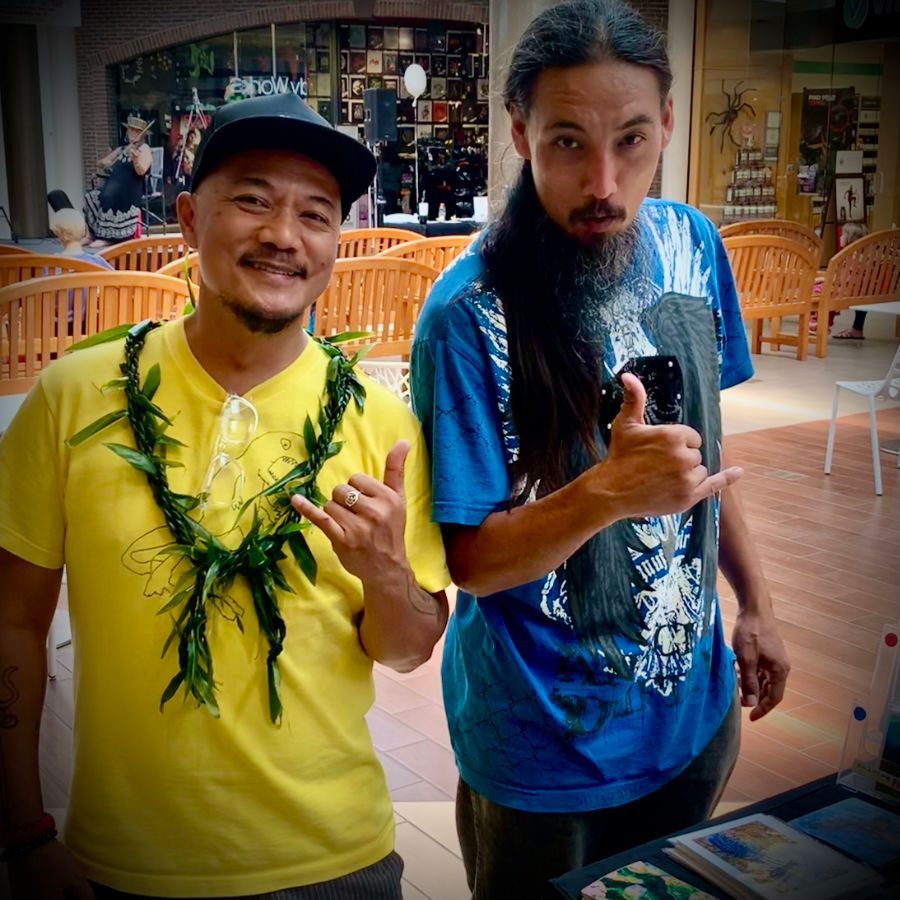 Two men are posing for a picture and one is wearing a lei around his neck