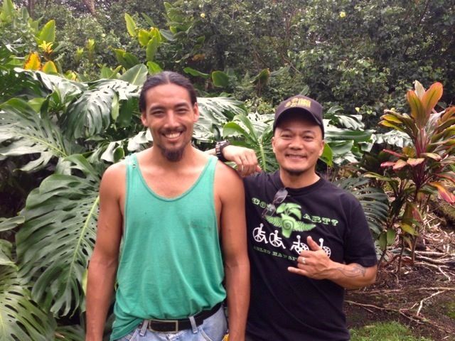 Two men standing next to each other with one wearing a shirt that says ' aloha ' on it