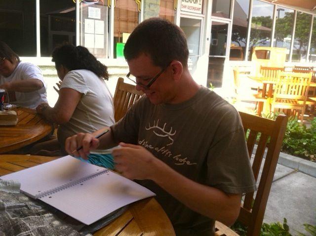 A man sitting at a table with a deer on his shirt