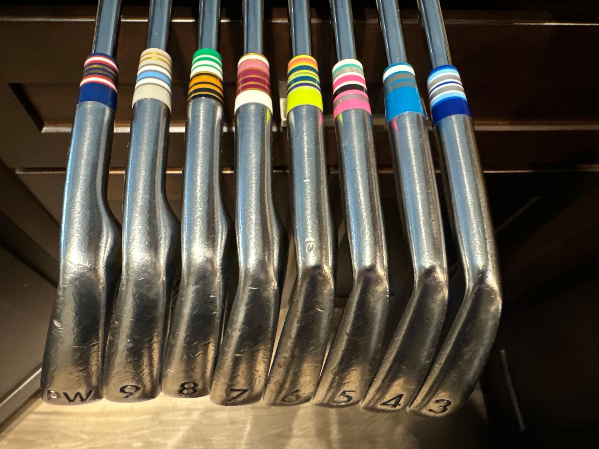 A bunch of golf clubs are lined up in a row
