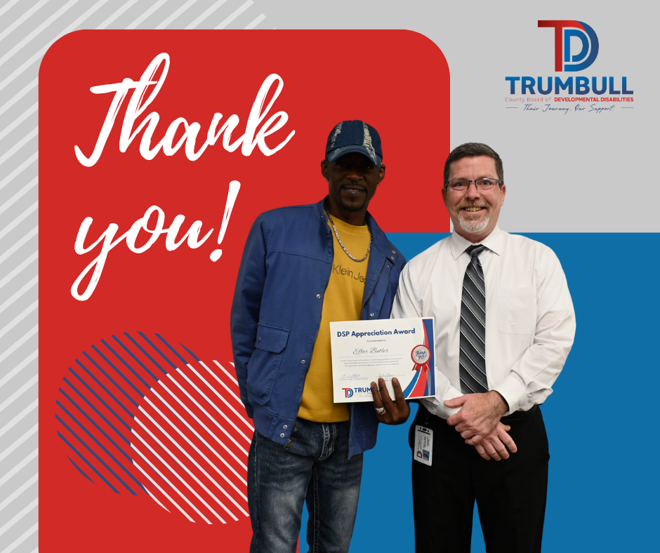 Man in blue jacket receives award from another man,