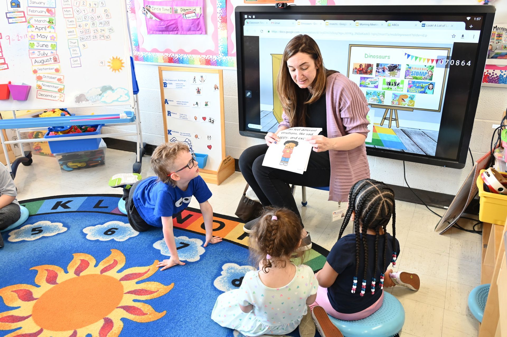 Teacher showing card to preschool children in classroom.