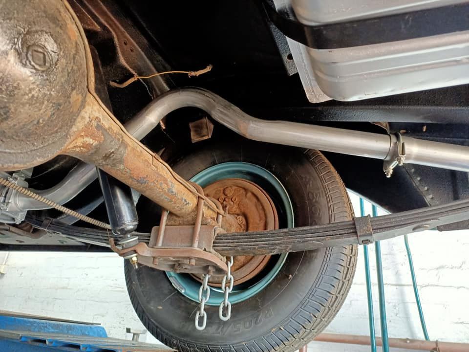 A Close Up Of The Underside Of A Car With A Tire And Exhaust Pipe — Coughrans Auto Centre  In Toowoomba, QLD