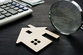 Magnifying glass and wooden house cutout