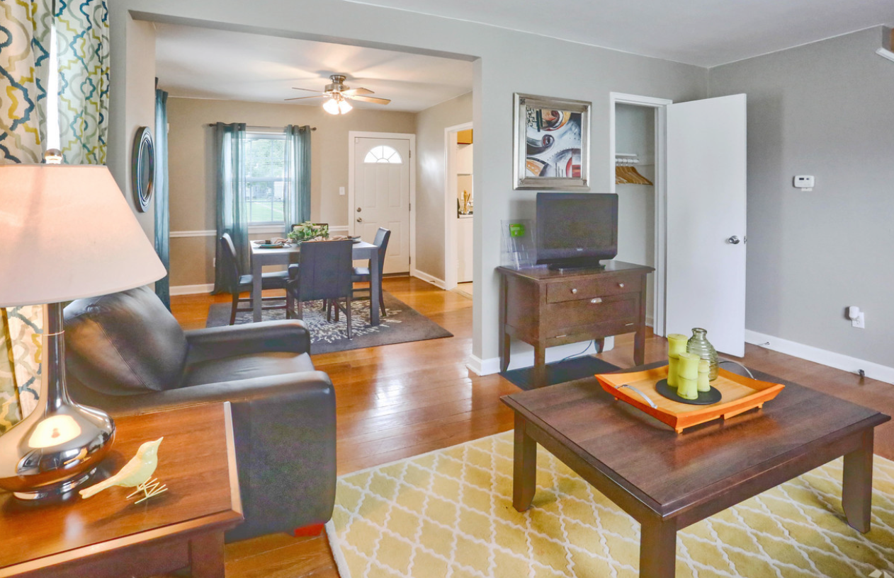 A living room with a couch , chair , coffee table and television.