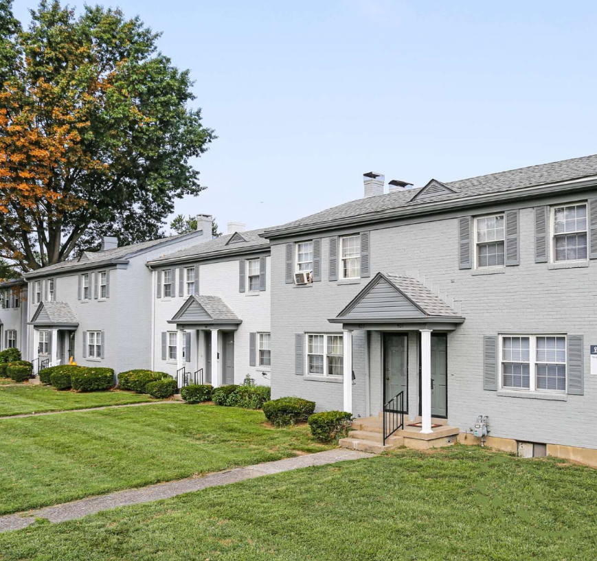 A row of houses are sitting next to each other on a lush green lawn.