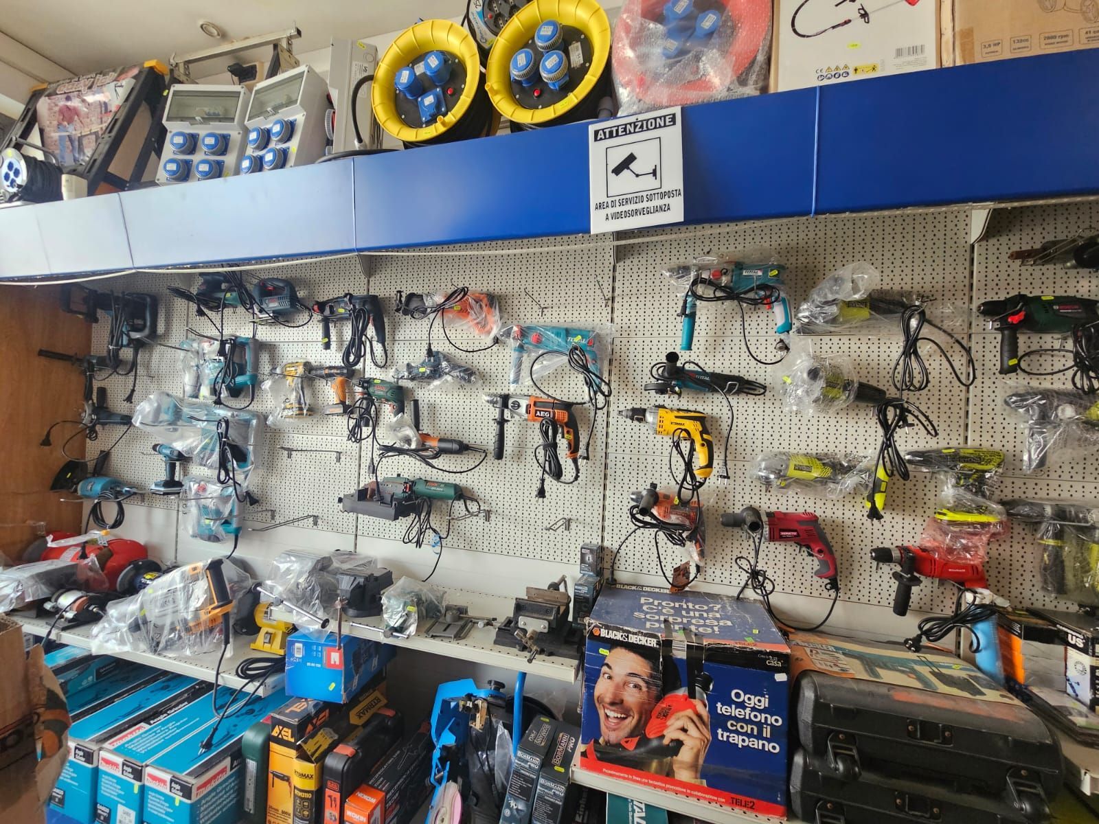 Un mucchio di attrezzi è appeso al muro di un negozio.