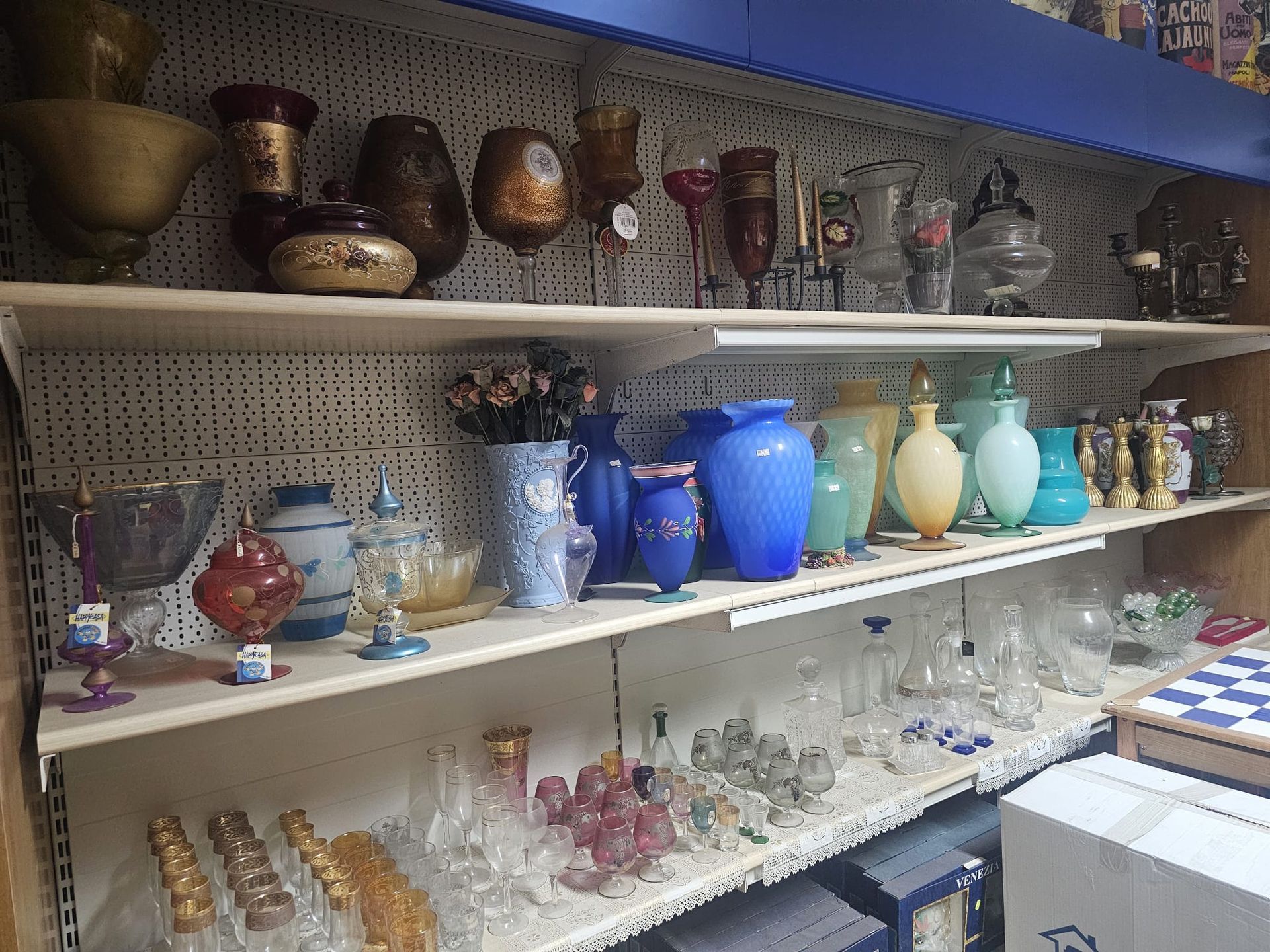 Uno scaffale di un negozio pieno di vasi e bicchieri