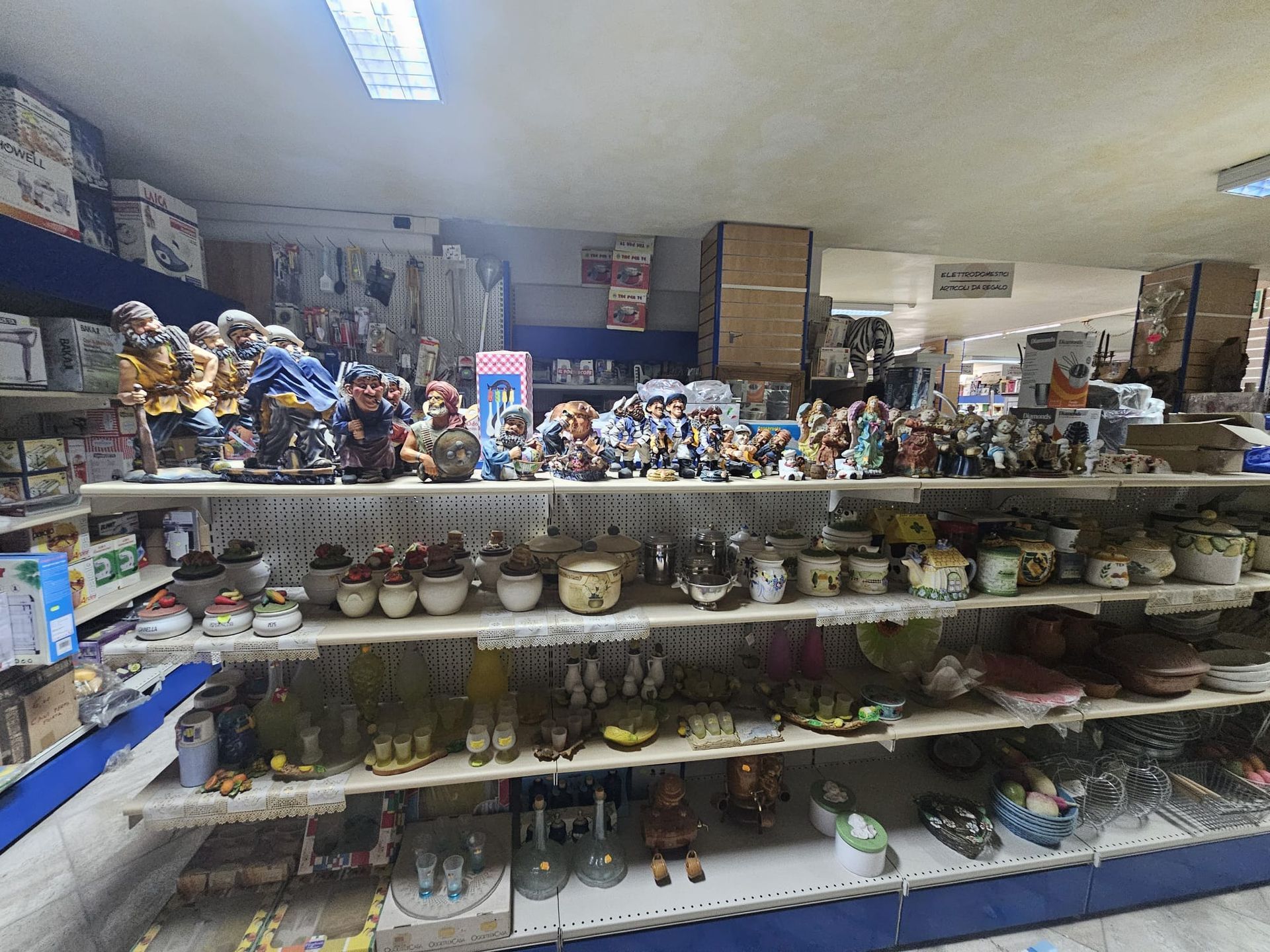 Un negozio pieno di statuette sugli scaffali.