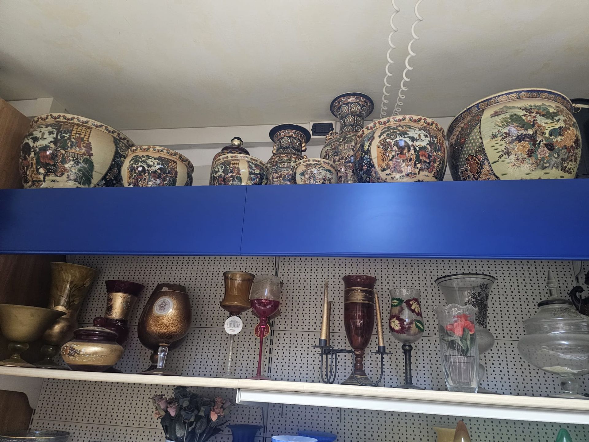 Uno scaffale con un sacco di vasi e candele sopra