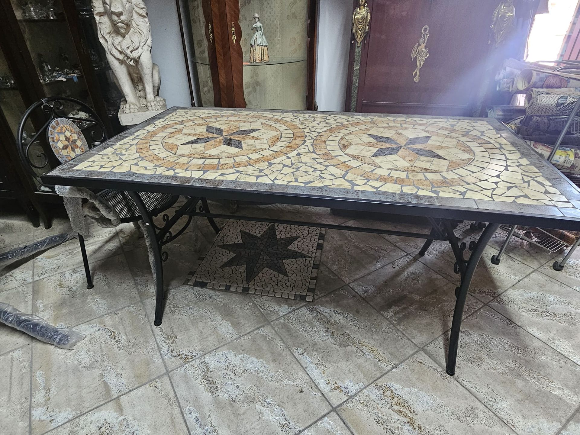 Un tavolo e delle sedie in mosaico sono appoggiati su un pavimento piastrellato.