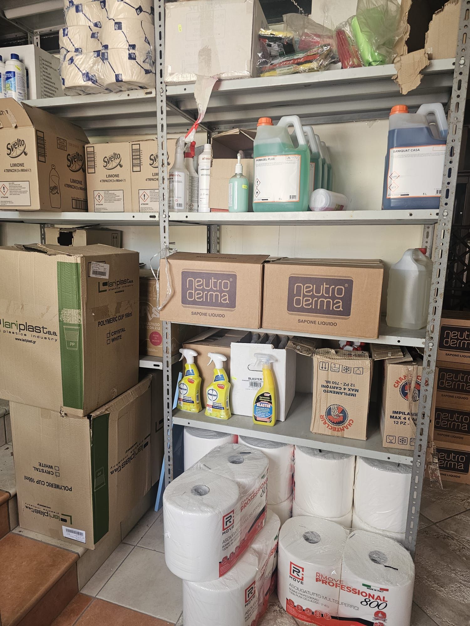 Uno scaffale pieno di scatole e rotoli di carta igienica.