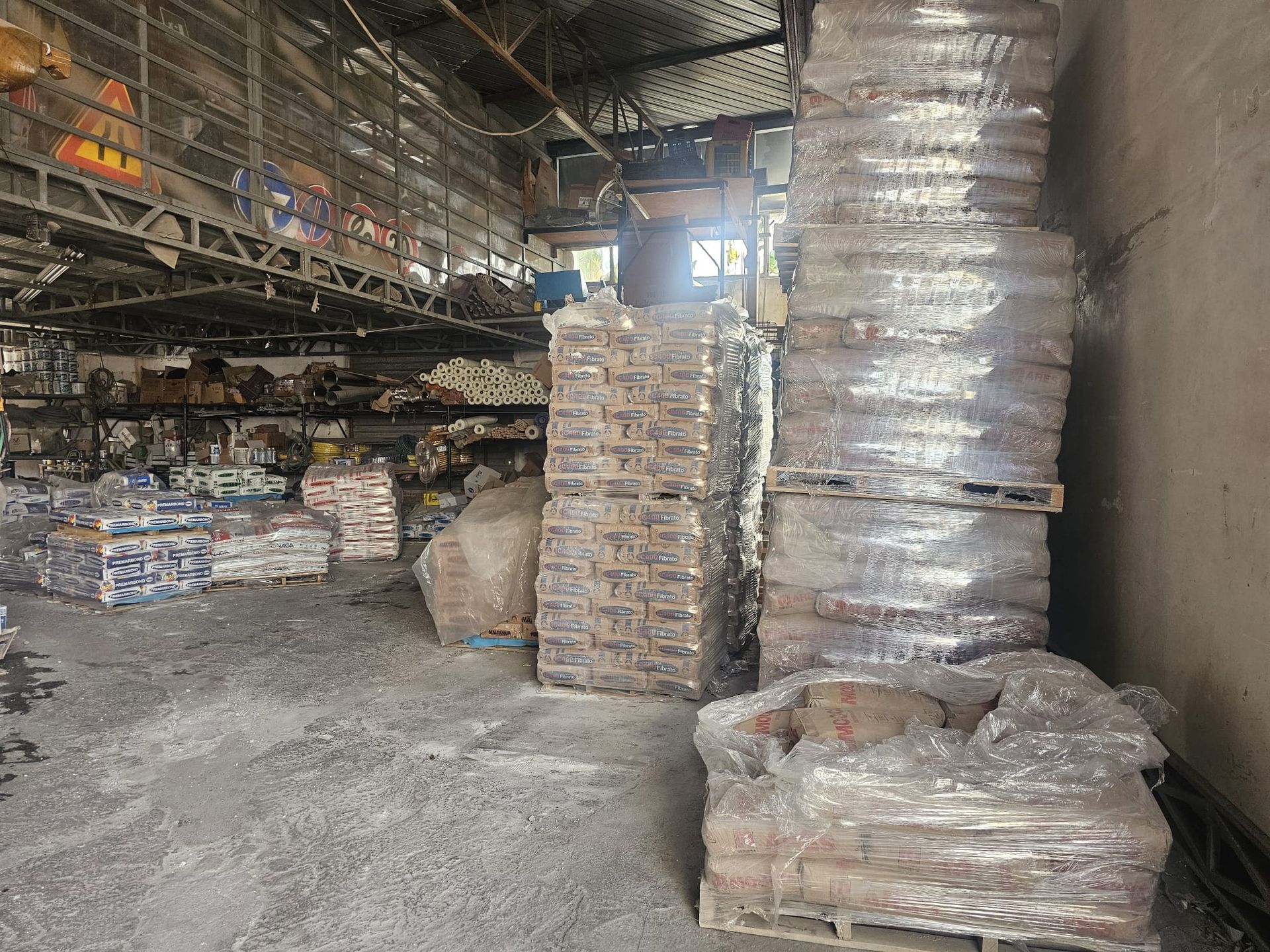 Un grande magazzino pieno di sacchi e pallet.