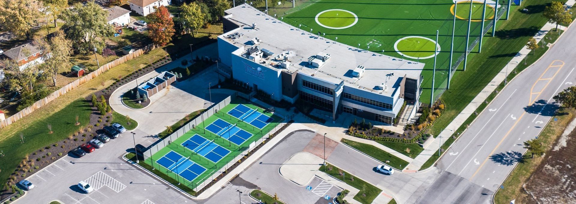 An aerial view of a tennis court and a football field.