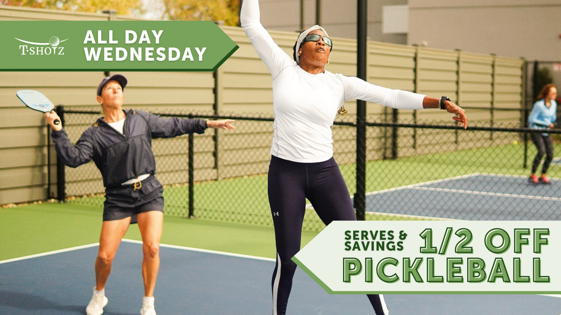 Two women are playing pickleball outdoors with a promotional sign for half-price play on Wednesdays.