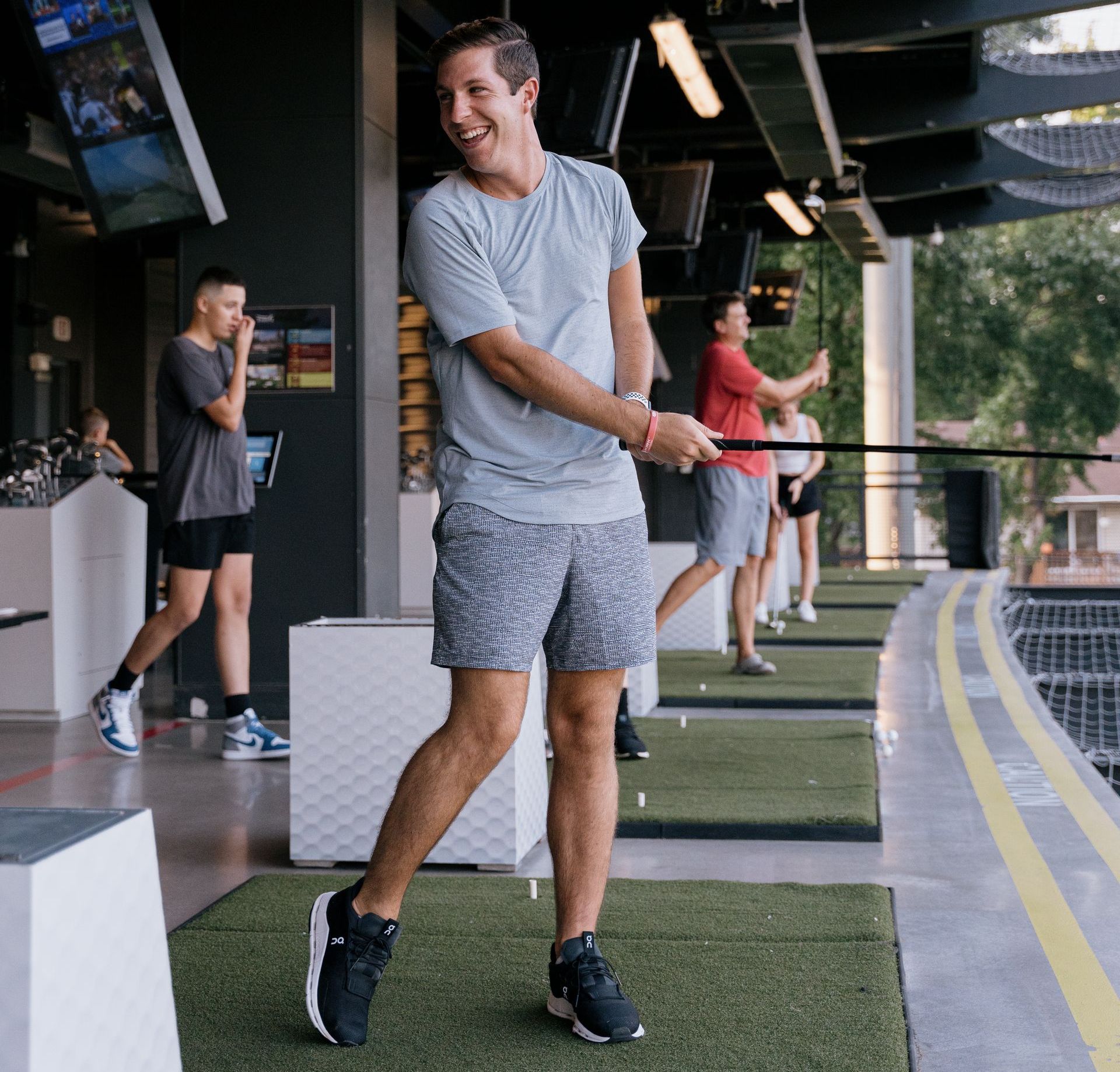 A group of people are playing golf in a gym.