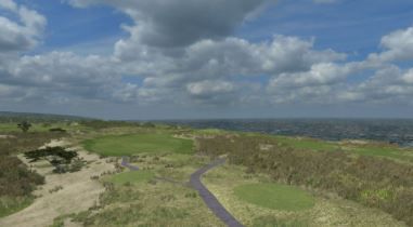 An aerial view of a golf course with a road going through it.