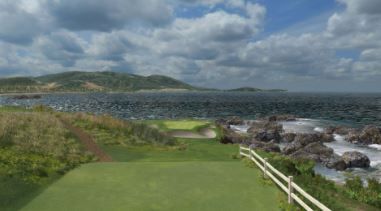 A golf course with a view of the ocean and mountains in the background.