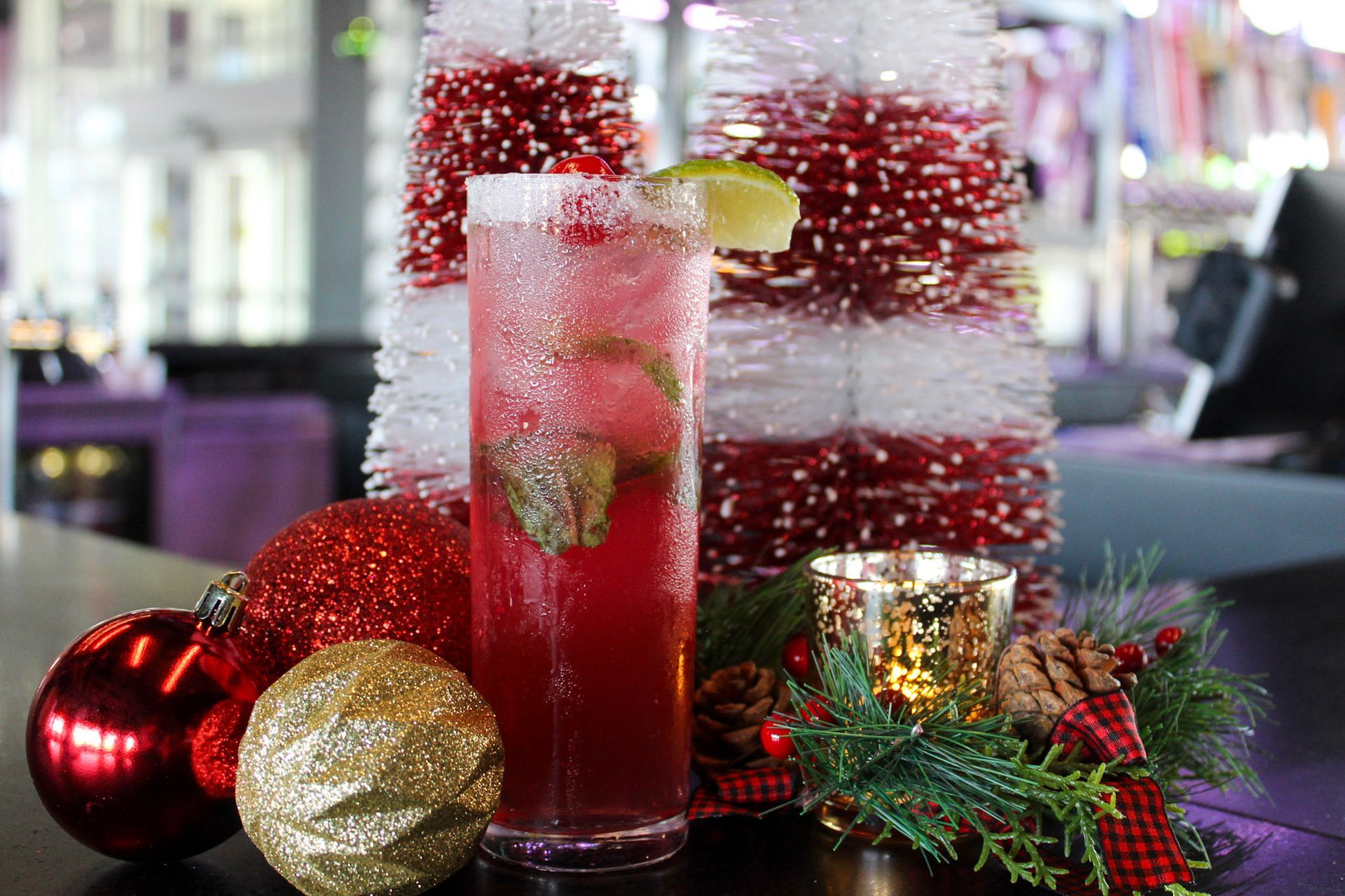 Three young women are posing for a picture together at night.